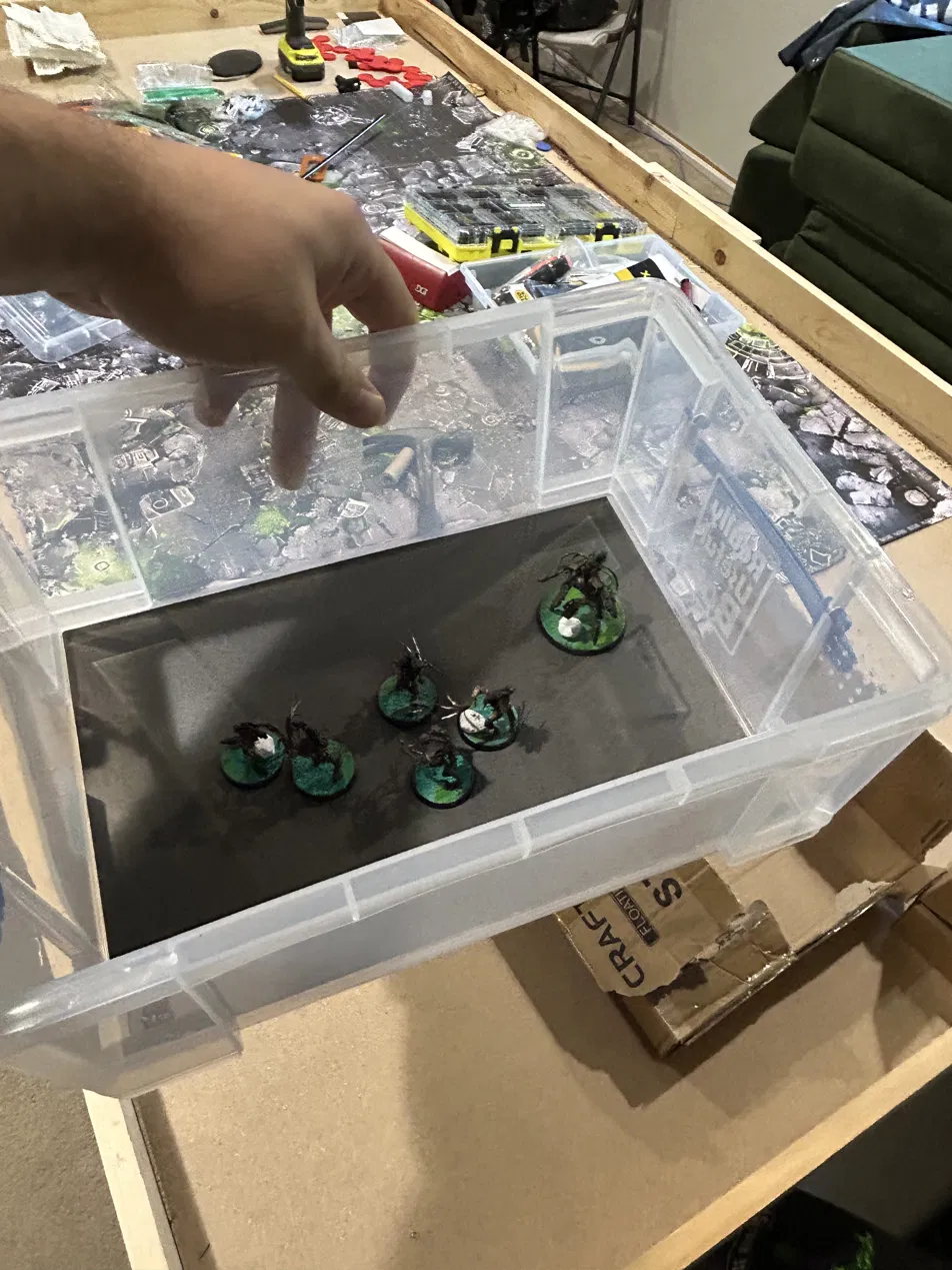Ork miniatures standing on the black magnetic sheet inside a clear 9-liter Really Useful Box